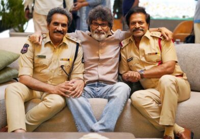 Black and white working still of actor Victory Venkatesh and director Trivikram Srinivas discussing on the sets of the Telugu movie Aadarsha Kutumbam next to a train carriage.